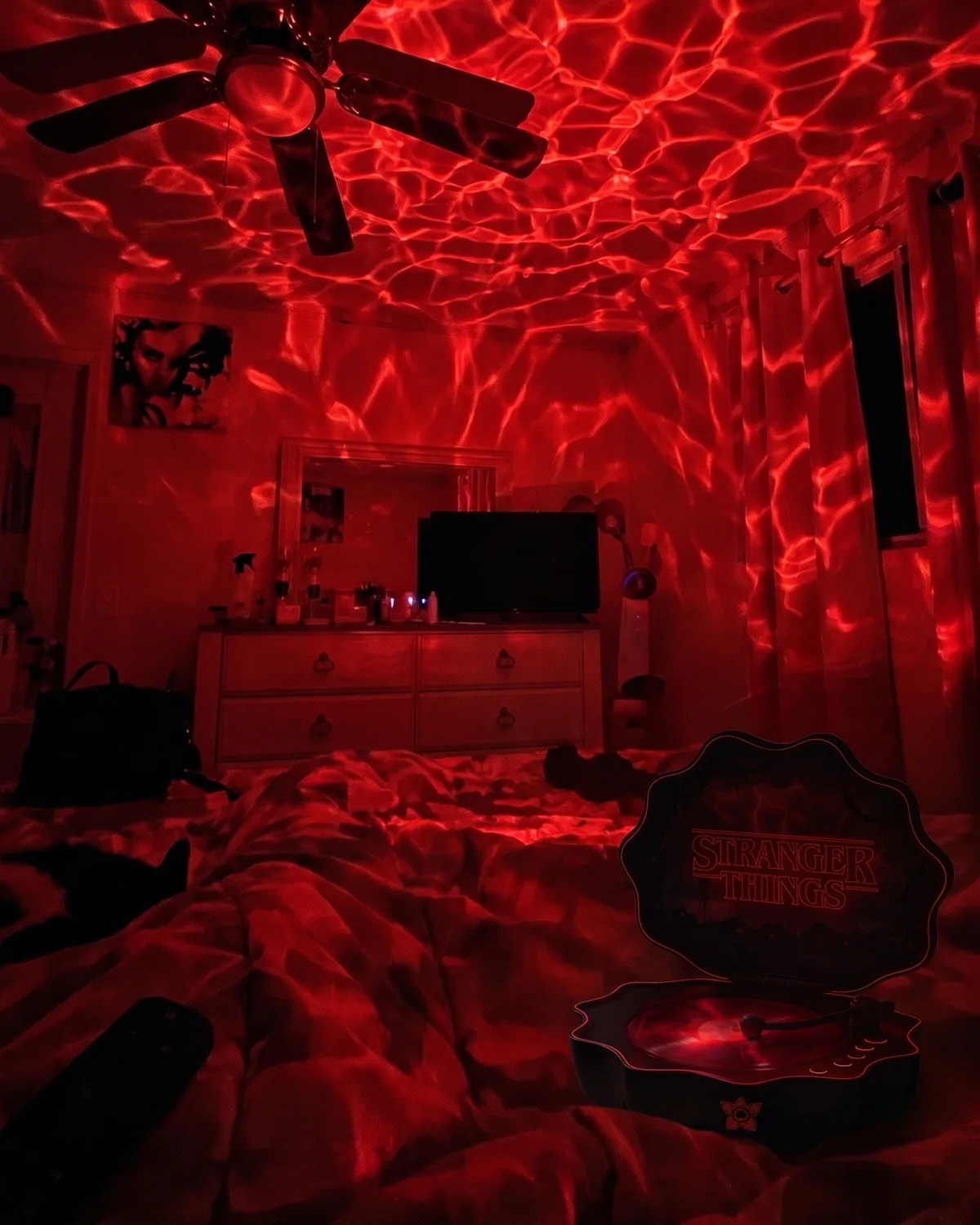 Upside Glow shell speaker on a bed turning the dark bedroom red